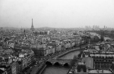 Seine river in city with historic eiffel tower against sky