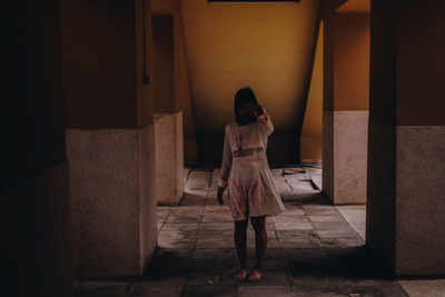 Rear view of woman standing against building