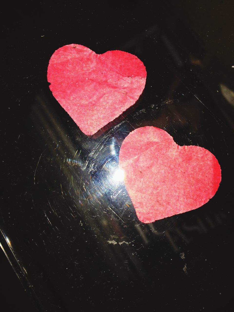 red, high angle view, close-up, black background, studio shot, water, still life, indoors, heart shape, reflection, no people, pink color, night, directly above, single object, love, ideas, creativity, black color, dark