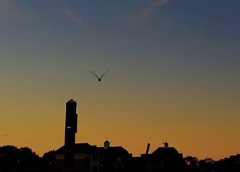 Low angle view of silhouette built structure against sky at sunset