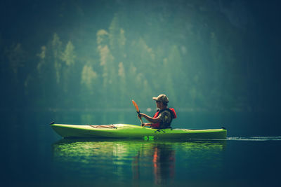 Side view of man kayaking in lake