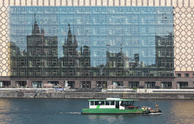 Window reflection of city skyline with boat in foreground