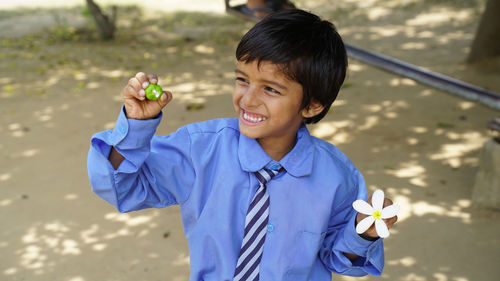 Portrait of young woman blowing bubbles while standing outdoors