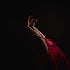 Close-up of woman hand against black background