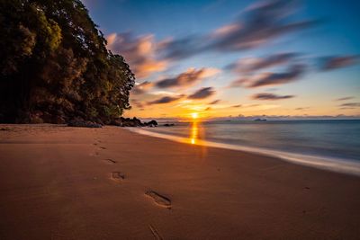 Scenic view of beach against sky during sunset