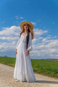 Woman wearing hat standing against sky