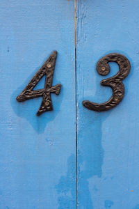 House number 43 on a blue wooden front door in london 