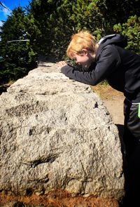 Side view of curious boy looking at retaining wall at crater lake national park