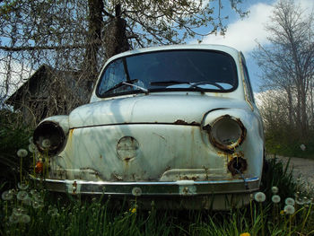 Abandoned vintage car against sky