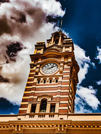 Low angle view of clock tower against cloudy sky