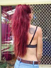 Rear view of woman standing against wall