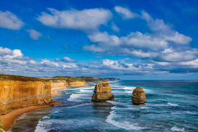Rocks on sea shore against sky