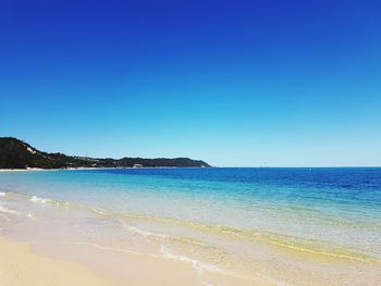 View of calm beach against blue sky