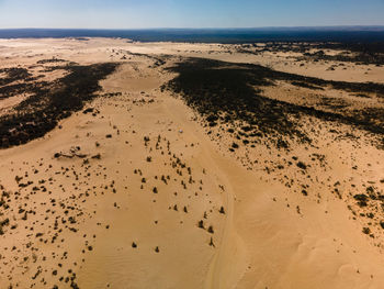 Scenic view of sand dunes against sky