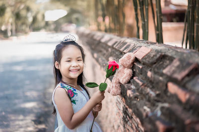 Portrait of cute girl smiling while standing on plant