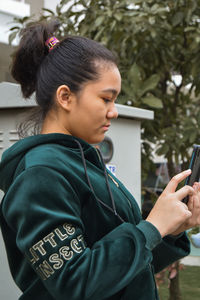 Side view of woman using mobile phone