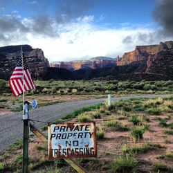Road sign against cloudy sky