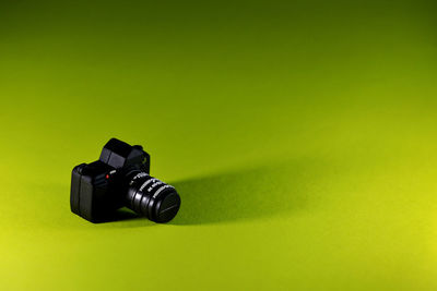 Close-up of miniature camera over green background