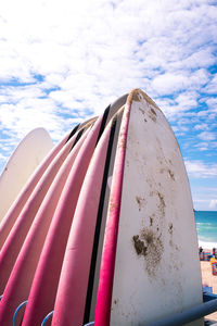 Low angle view of pink ship on beach against sky