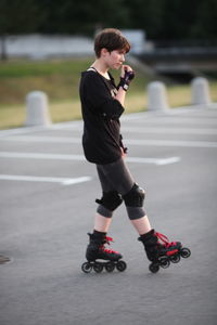 Full length of girl roller skating on road