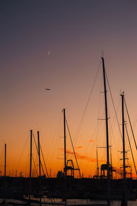 Silhouette sailboats at harbor against sky during sunset