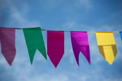 Festive decoration flags of different colors hanging with string. decorative plastic.