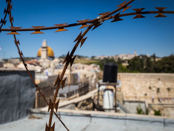 Close-up of metal fence against blue sky