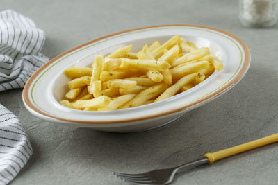 Portion of french fries on white plate, close up . concept fast food