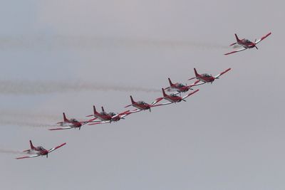 Low angle view of fighter planes flying against sky