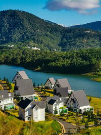 Houses by lake and buildings against sky