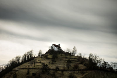 Low angle view of man standing on mountain against sky