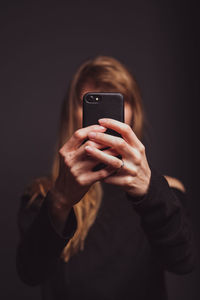 Woman using mobile phone over black background