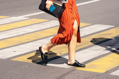 Low section of woman walking on road