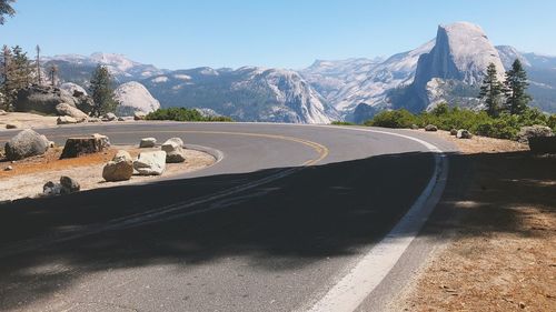 Road by mountain against sky