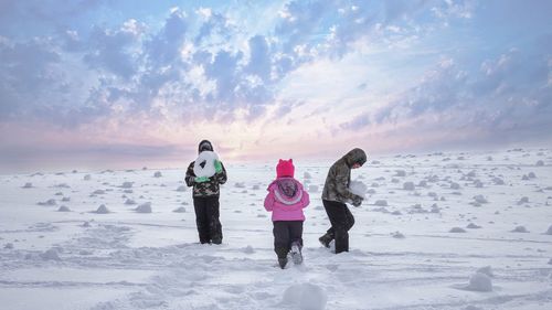 Full length of boys on snow against sky during winter