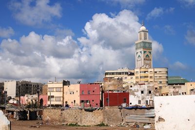 Buildings in city against cloudy sky