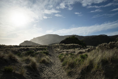 Scenic view of land and mountains against sky