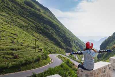 Rear view of man on mountain against sky