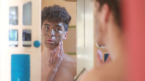 Portrait of shirtless man in bathroom