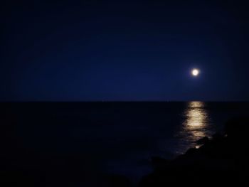 Scenic view of sea against clear sky at night