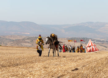 People on field against mountain range