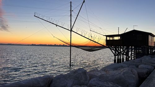 Fishing hut by pier at sunsets