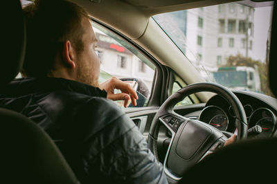 Close-up of man smoking in car