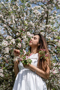 Portrait of young woman standing amidst plants