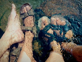 Low section of men with legs in water