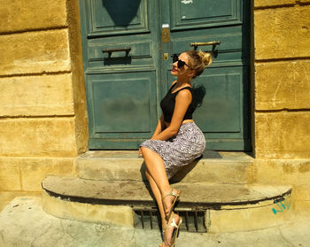 Full length of woman sitting outdoors