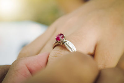 Close-up of man putting ring on woman hand
