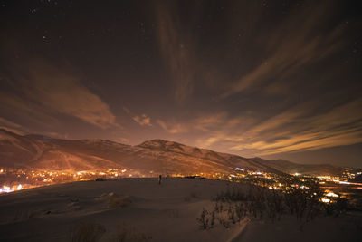 Scenic view of snowcapped mountains against sky at night