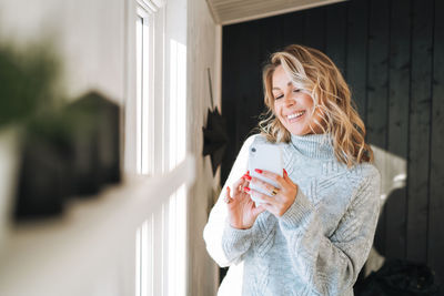 Young woman using mobile phone at home