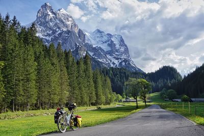 People riding bicycle on road against sky